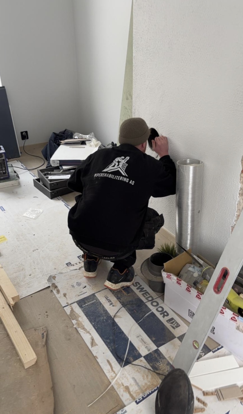 Tekniker fra Piperehabilitering AS utfører innvendig pipearbeid hos kunde i Skien