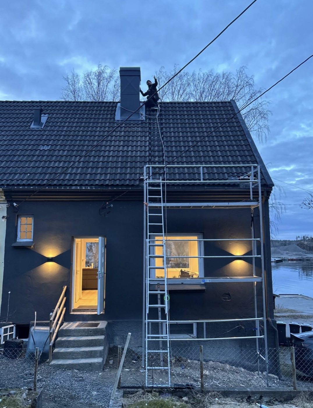 Piperehabilitering av tomannsbolig på Østre Tromøyvei, Kongshavn, stillas reist mot pipen i skumringen